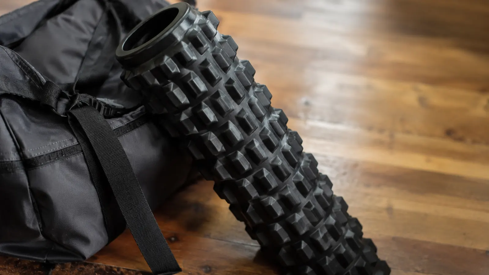 Woman sitting on the floor stretching after foam rolling, relaxed and comfortable at home